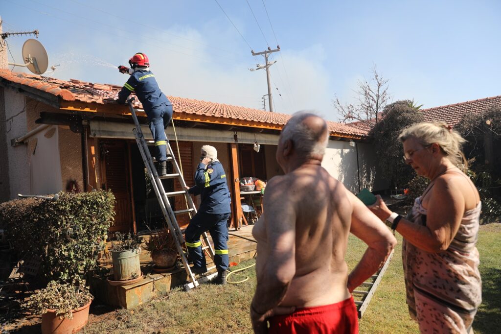 Πυροσβέστες σβήνουν εστία σε στέγη σπιτιού κατά τη διάρκεια της πυρκαγιάς στην Παλαιά Φώκαια Αττικής, Πέμπτη 26 Ιουνίου 2025. Μάχη με τις φλόγες συνεχίζουν να δίνουν οι πυροσβεστικές δυνάμεις στην πυρκαγιά που ξέσπασε λίγο μετά τις 12:30 σε χαμηλή βλάστηση ανάμεσα σε Θυμάρι και Παλαιά Φώκαια Αττικής. Όπως έγινε γνωστό από την Πυροσβεστική η φωτιά εκδηλώθηκε ανάμεσα σε κατοικίες με αποτέλεσμα να υπάρχουν αναφορές για καμένα σπίτια. Για τον λόγο αυτό τρία μηνύματα μέσω του 112 εστάλησαν σε κατοίκους προκειμένου να απομακρυνθούν από τις περιοχές Θυμάρι, Τουρκολίμανο, Καταφύγι και Χάρακα. ΑΠΕ-ΜΠΕ/ΑΠΕ-ΜΠΕ/ΓΙΩΡΓΟΣ ΒΙΤΣΑΡΑΣ