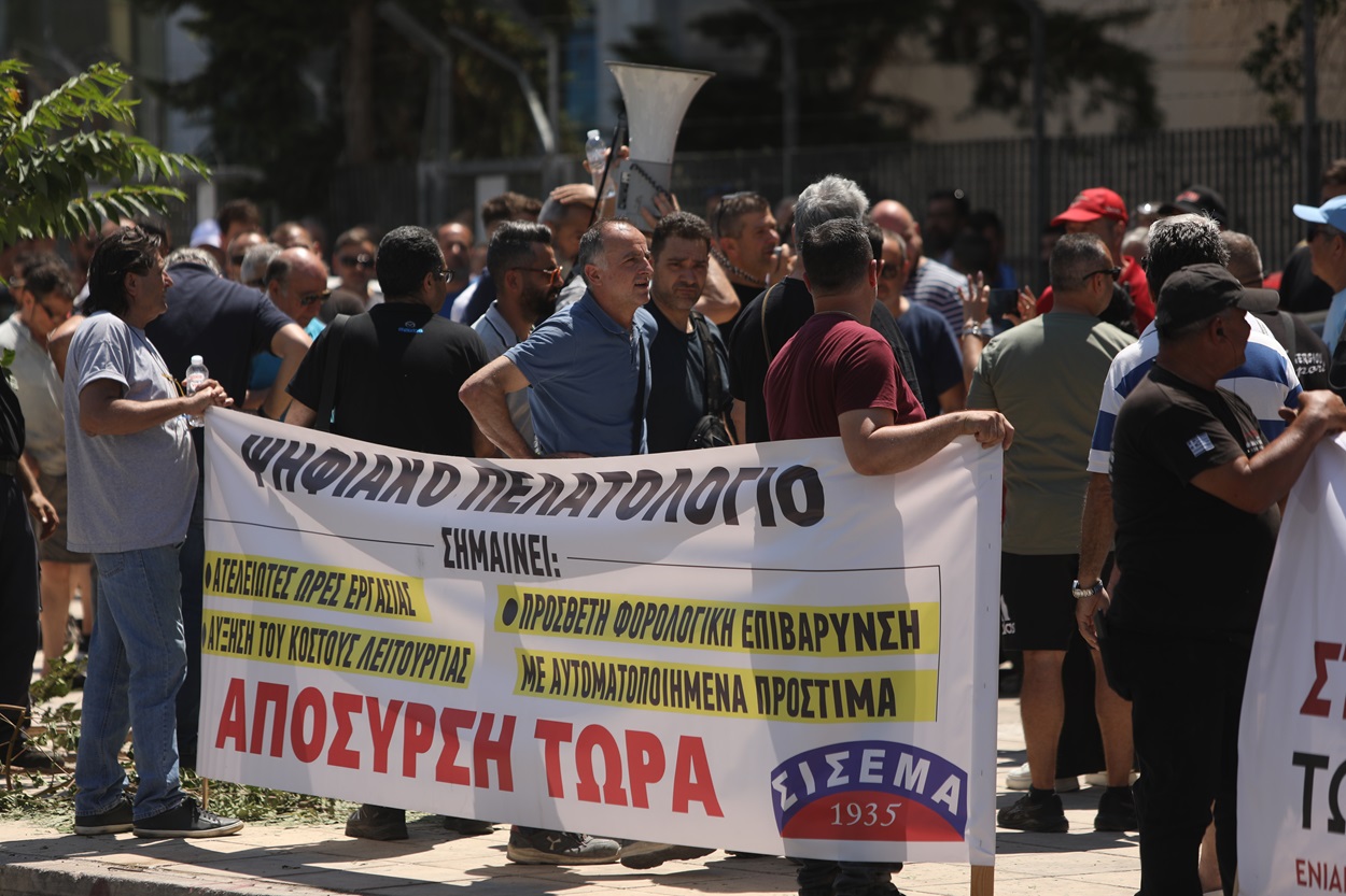 Ιδιοκτήτες συνεργείων αυτοκινήτων, φανοποιείων εταιρειών εγκατάστασης συναγερμών και ήχου σε οχήματα, πλυντηρίων, πάρκινγκ και επιχειρήσεων ενοικίασης αυτοκινήτων και μοτοσικλετών, πραγματοποιούν συγκέντρωση διαμαρτυρίας έξω από την κεντρική υπηρεσία της ΑΑΔΕ, Αθήνα ,Τρίτη 01 Ιουλίου 2025. Σε απεργία προχωρούν οι μικροί ιδιοκτήτες συνεργείων αυτοκινήτων σήμερα Τρίτη 01 Ιουλίου, πρώτη μέρα εφαρμογής του «Ψηφιακού Πελατολογίου», δίνοντας συνέχεια στις κινητοποιήσεις τους για την απόσυρση του μέτρου, που έρχεται να βάλει θηλιά στα μικρά συνεργεία, εντατικοποιώντας ακόμα περισσότερο τη δουλειά τους. ΑΠΕ-ΜΠΕ/ΑΠΕ-ΜΠΕ/ΓΙΩΡΓΟΣ ΒΙΤΣΑΡΑΣ